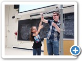 A young audience member assists with the pendulum demonstration