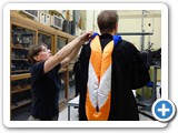 Department Administrator Julie Morrison adjusts Professor Richard J. Rand's gown and hood