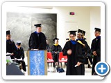 Regent's Lecturer and Associate Professor Dinesh Loomba places the doctoral hood over PhD graduate Nguyen Phan's head — at Regener Hall.