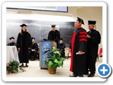 Brian Kamer receives his hood from Department Chair Wolfgang Rudolph in lieu of Dissertation Director Jean-Claude Diels — at Regener Hall.